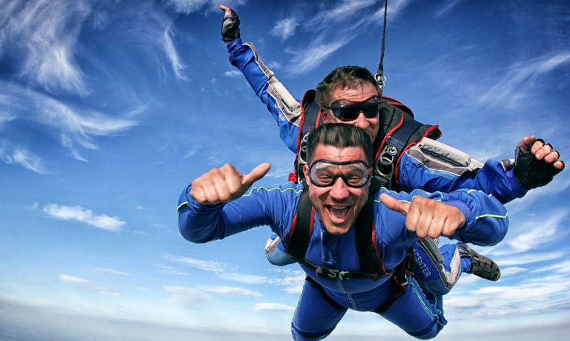 мужчина прыгает с парашютом с инструктором